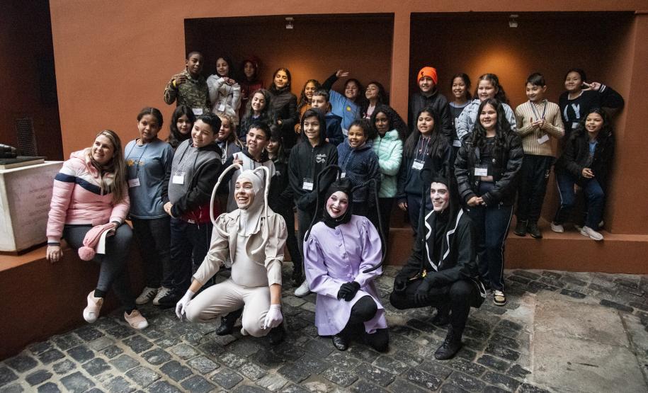 Estudantes junto com elenco de espetáculo infantil que contou com recrutamento de equipe por meio da Agência do Trabalhador da Cultura (ATC)